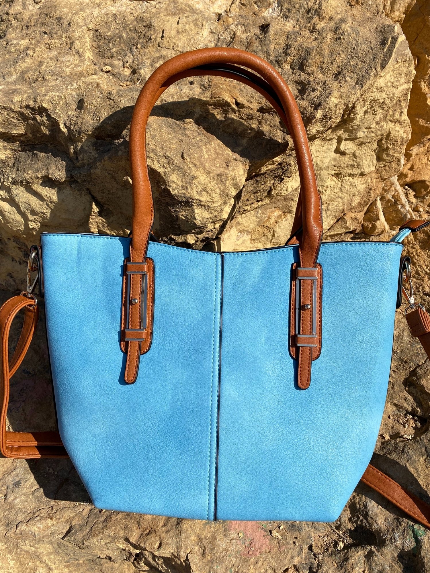 Light blue tote bag with zip closure, metallic details, and adjustable shoulder strap.