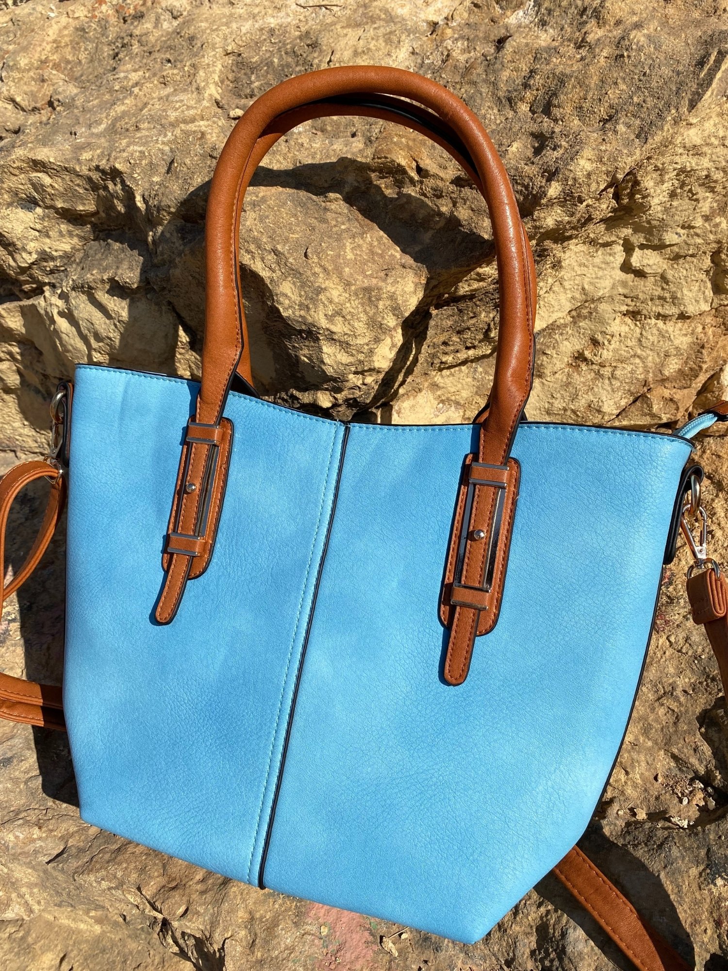 Light blue tote bag with zip closure, metallic details, and adjustable shoulder strap.