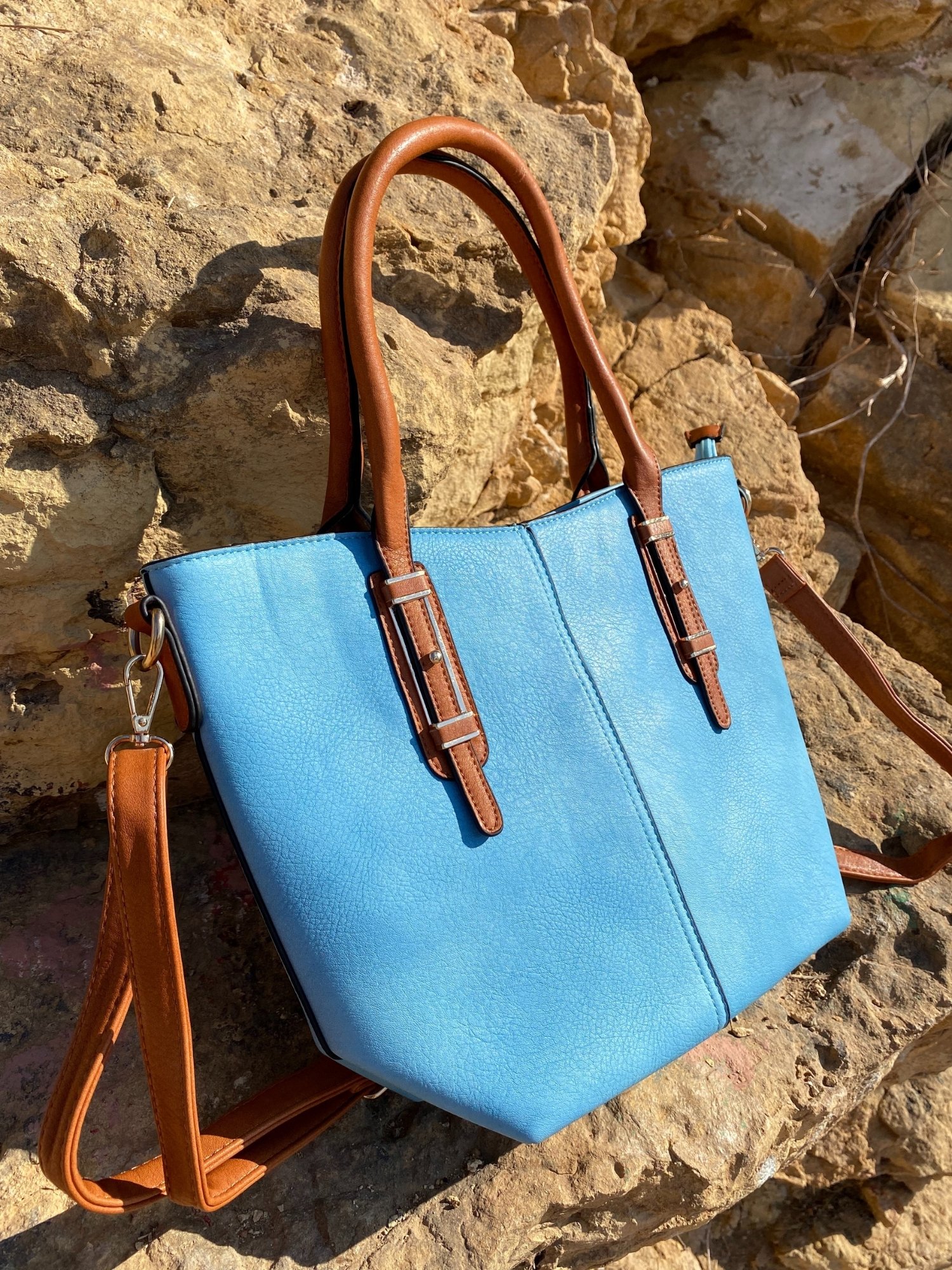 Light blue tote bag with zip closure, metallic details, and adjustable shoulder strap.