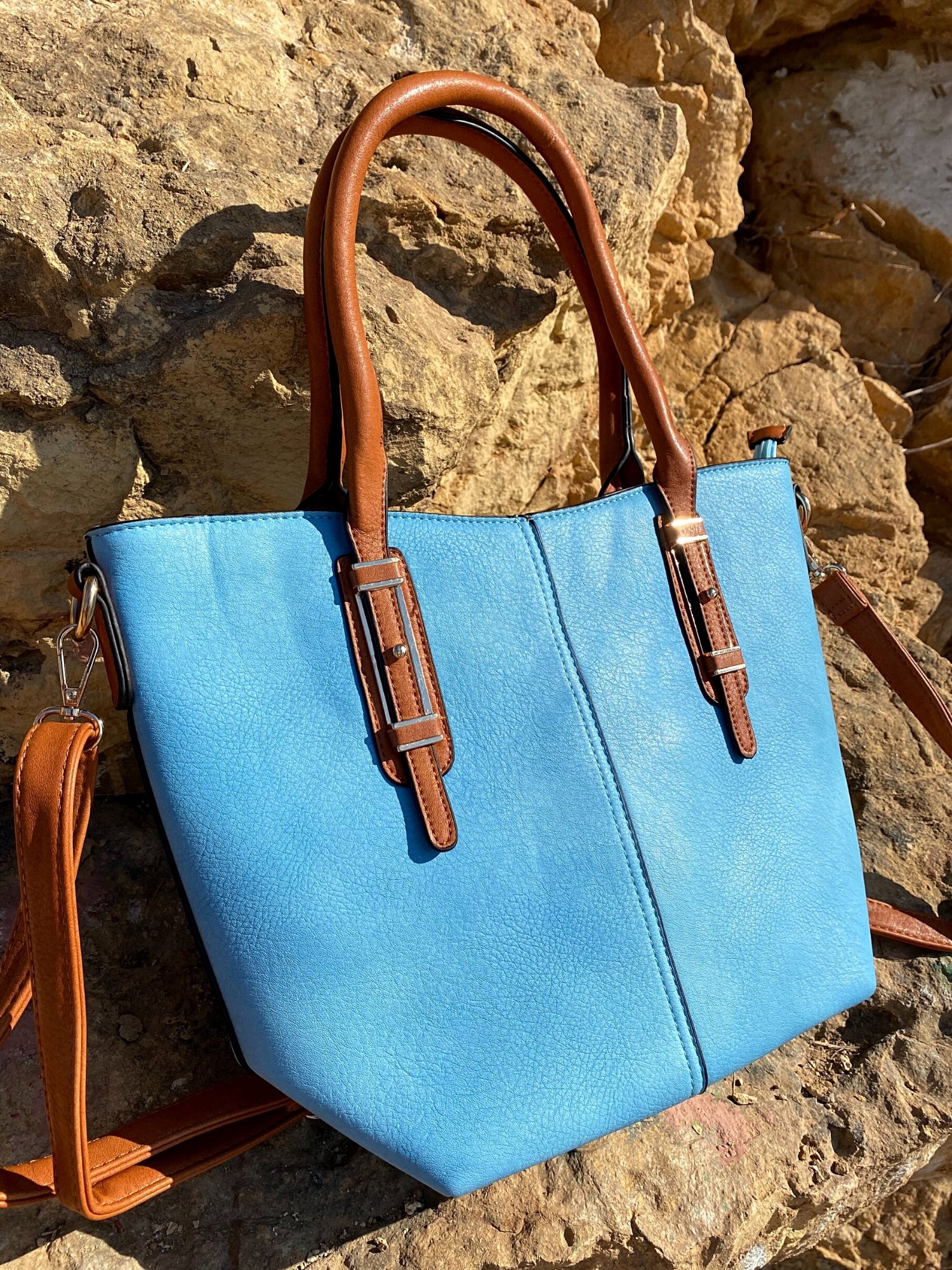 Light blue tote bag with zip closure, metallic details, and adjustable shoulder strap.