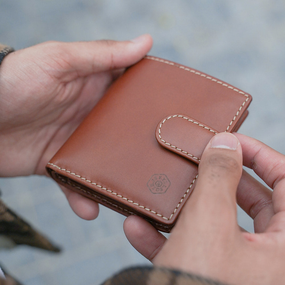 Tri Fold Wallet in Clay color with zipped coin pouch, showcasing its compact design and stylish appearance.