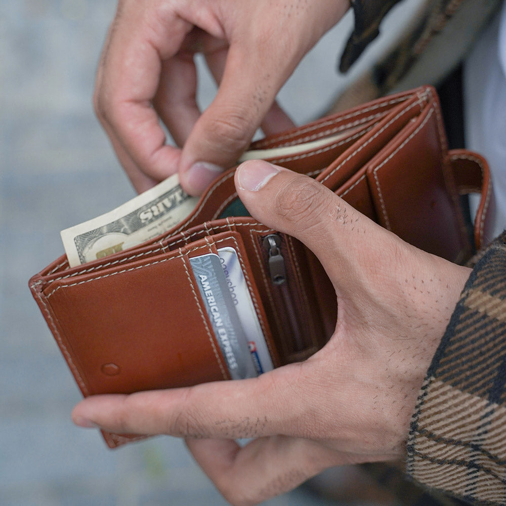 Tri Fold Wallet in Clay color with zipped coin pouch, showcasing its compact design and stylish appearance.