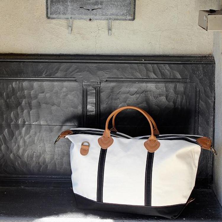 Weekender Duffel bag featuring real leather trim and antiqued brass hardware, made of heavyweight cotton canvas, perfect for travel.