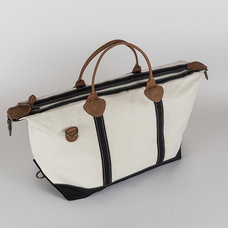 Weekender Duffel bag featuring real leather trim and antiqued brass hardware, made of heavyweight cotton canvas, perfect for travel.