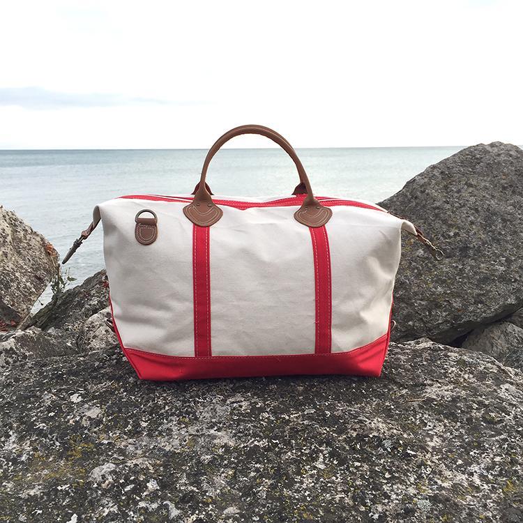 Weekender Duffel bag featuring real leather trim and antiqued brass hardware, made of heavyweight cotton canvas, perfect for travel.