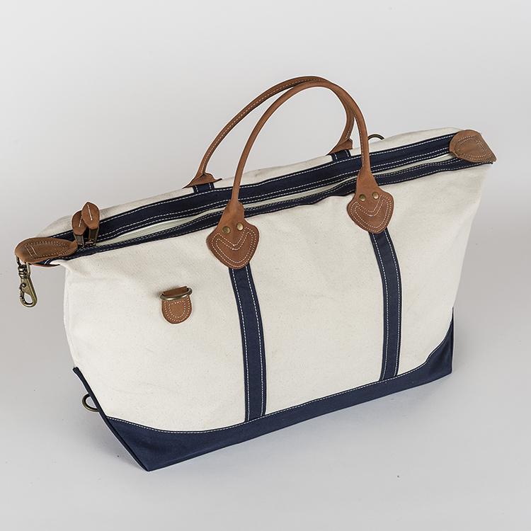 Weekender Duffel bag featuring real leather trim and antiqued brass hardware, made of heavyweight cotton canvas, perfect for travel.