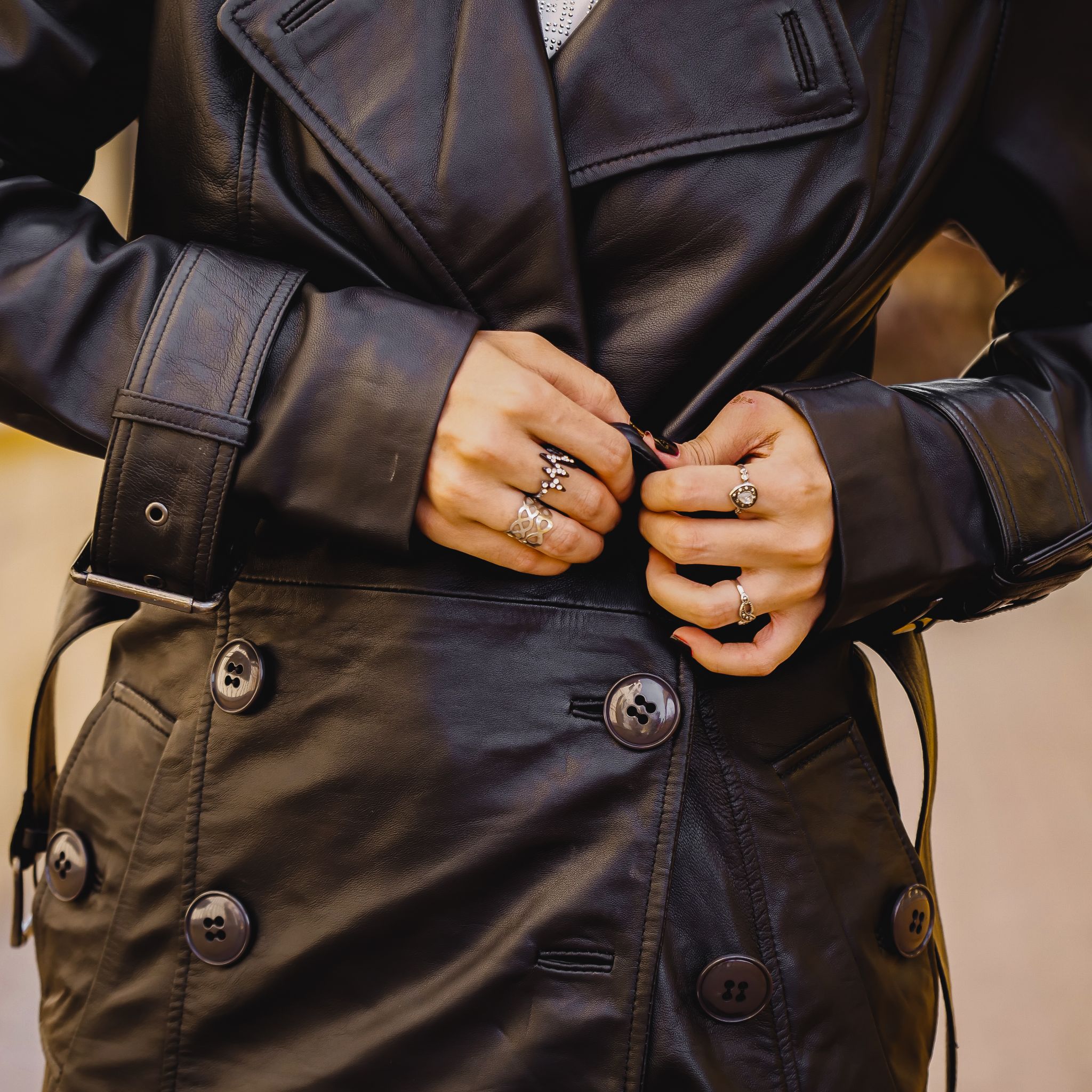 A stylish Women's Leather Long Coat in Black, featuring a double-breasted design and adjustable belt, made from 100% real lambskin leather.