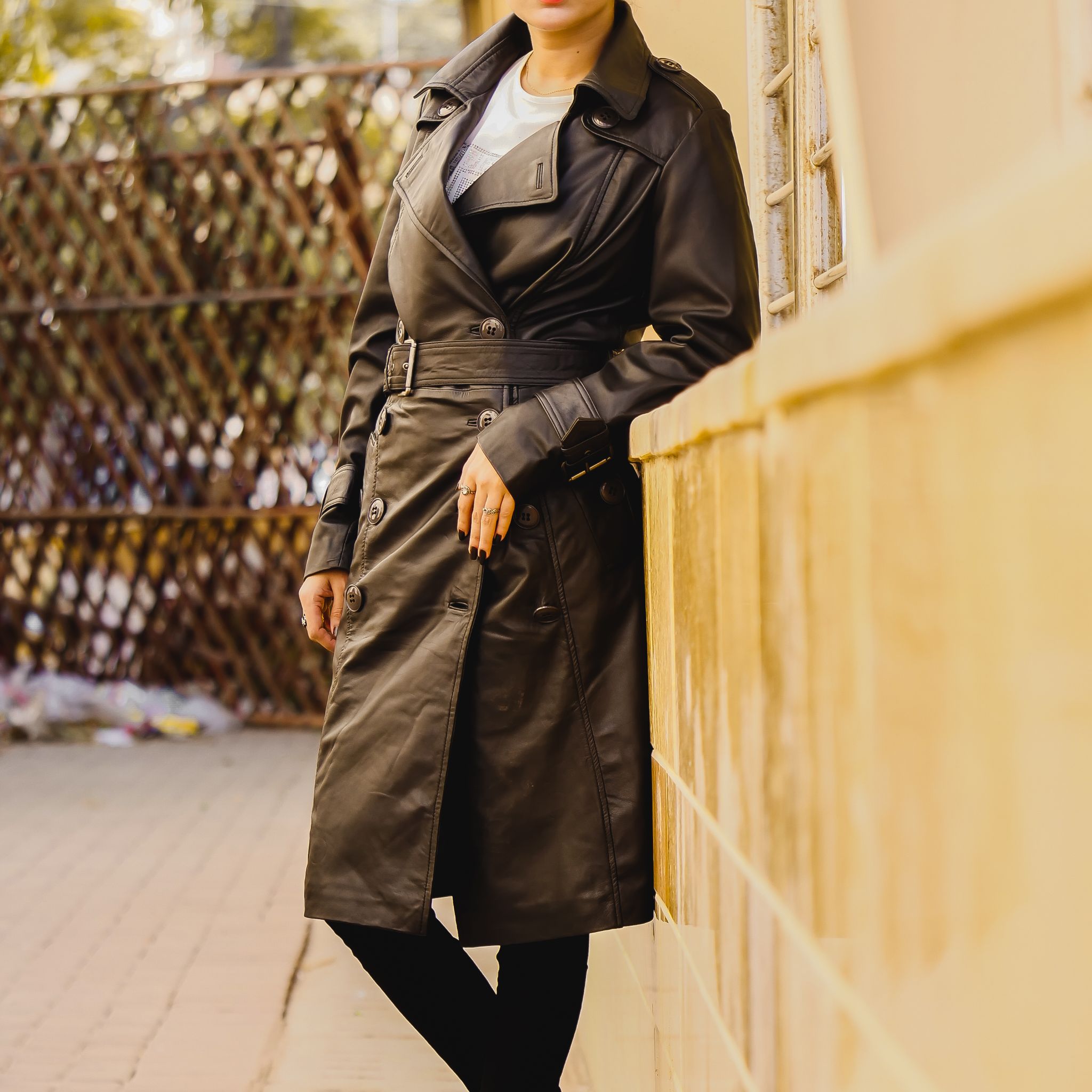 A stylish Women's Leather Long Coat in Black, featuring a double-breasted design and adjustable belt, made from 100% real lambskin leather.