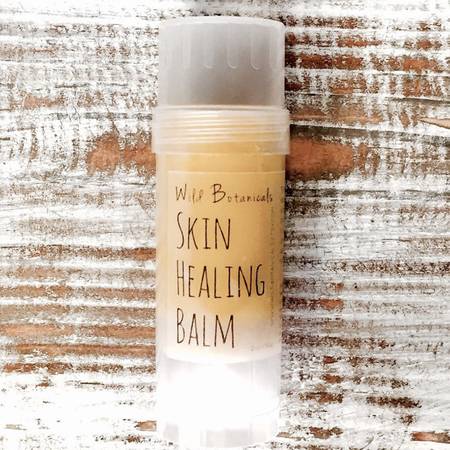 A 2oz jar of vegan skin healing balm with a smooth texture, surrounded by natural ingredients like coconut oil and shea butter.