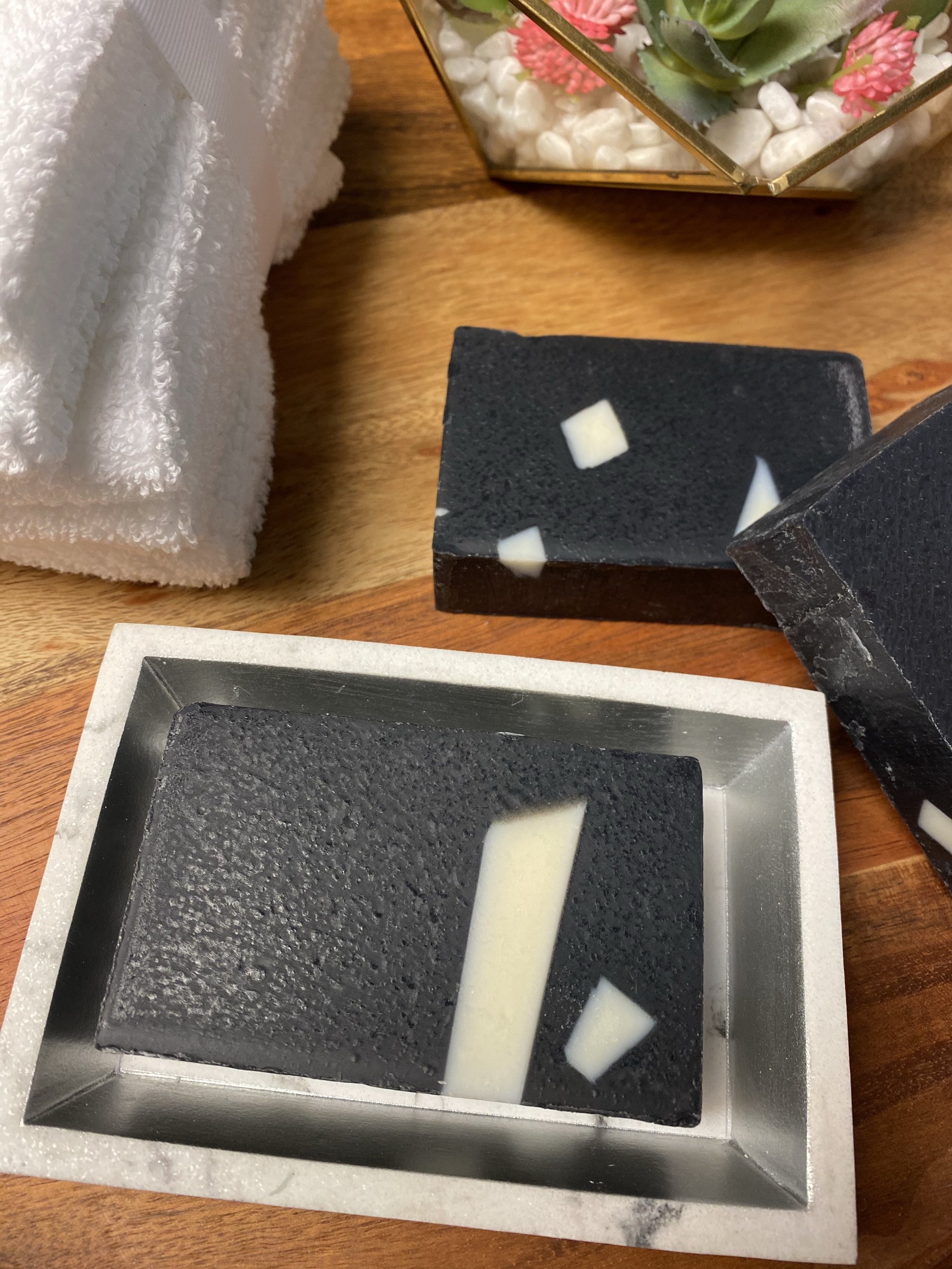 Activated Charcoal Aloe Soap bar with creamy lather, showcasing its natural ingredients and rich texture.