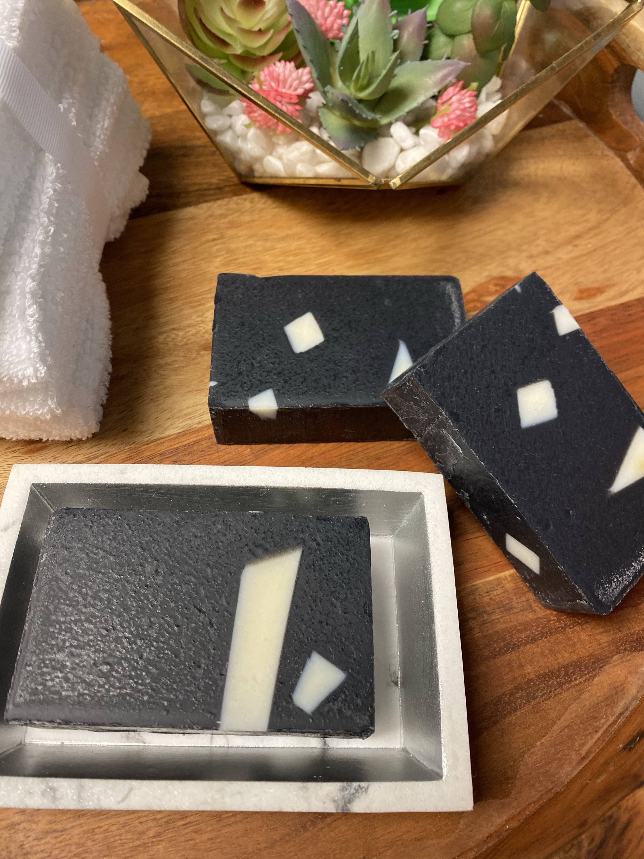 Activated Charcoal Aloe Soap bar with creamy lather, showcasing its natural ingredients and rich texture.