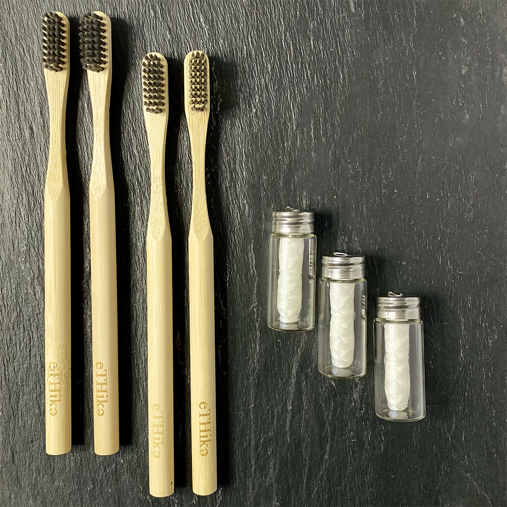 Bamboo Oral Hygiene Care Set of 7 featuring charcoal toothbrushes and mint floss in a glass container, showcasing eco-friendly dental care.