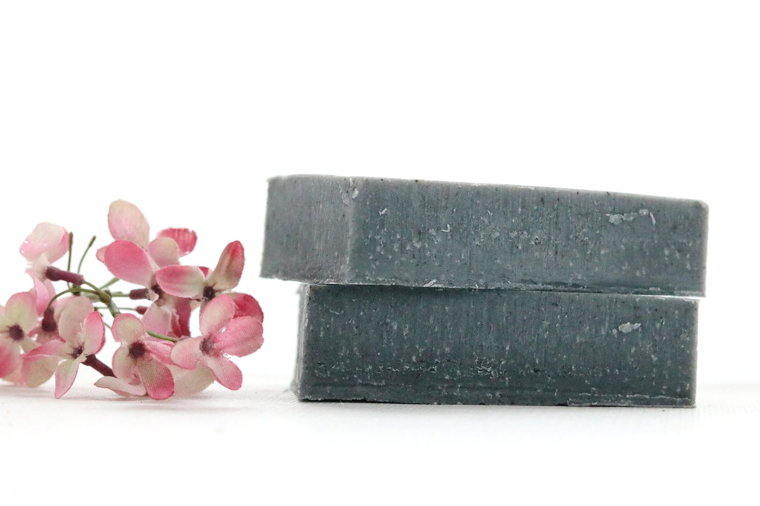 A bar of Black Tourmaline Soap with a smooth texture, showcasing its dark color and natural ingredients, resting on a wooden surface.