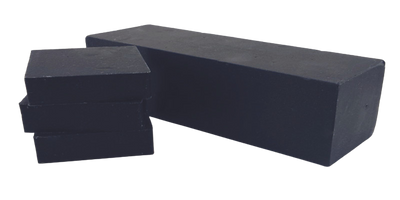 Blackout Shea soap bar with activated charcoal, featuring oakmoss and aloe fragrance, displayed on a natural wooden surface.