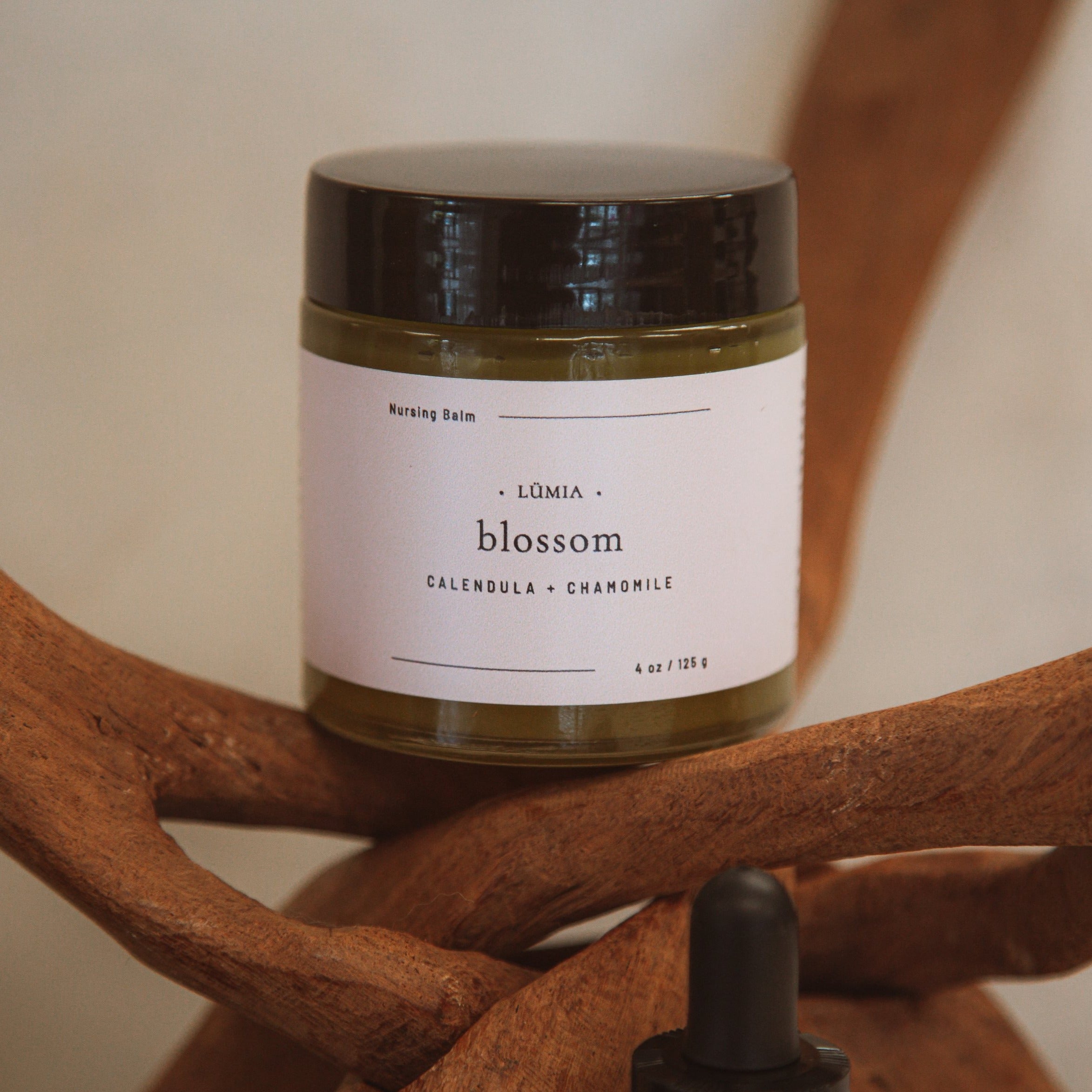 Blossom Nursing Balm in a 4 oz jar, featuring a blend of herbal ingredients for breastfeeding mothers.