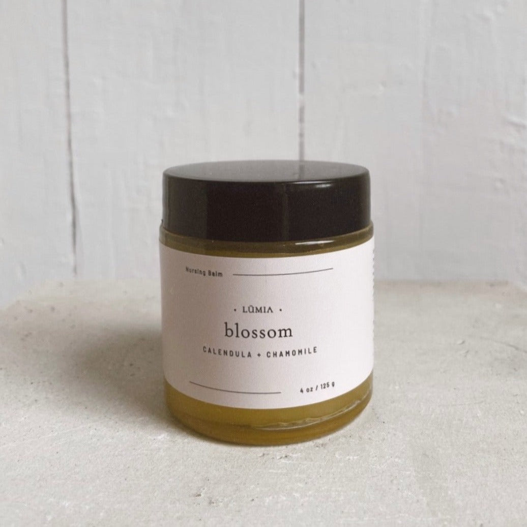 Blossom Nursing Balm in a 4 oz jar, featuring a blend of herbal ingredients for breastfeeding mothers.