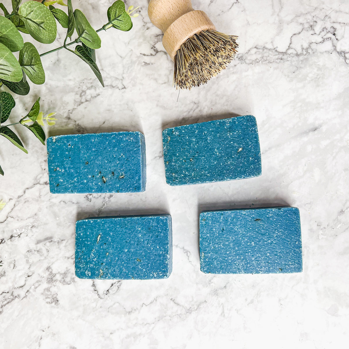 A vibrant blue bar of Blueberry Scrub soap with visible oatmeal and sea salt, showcasing its handcrafted design and rich color.