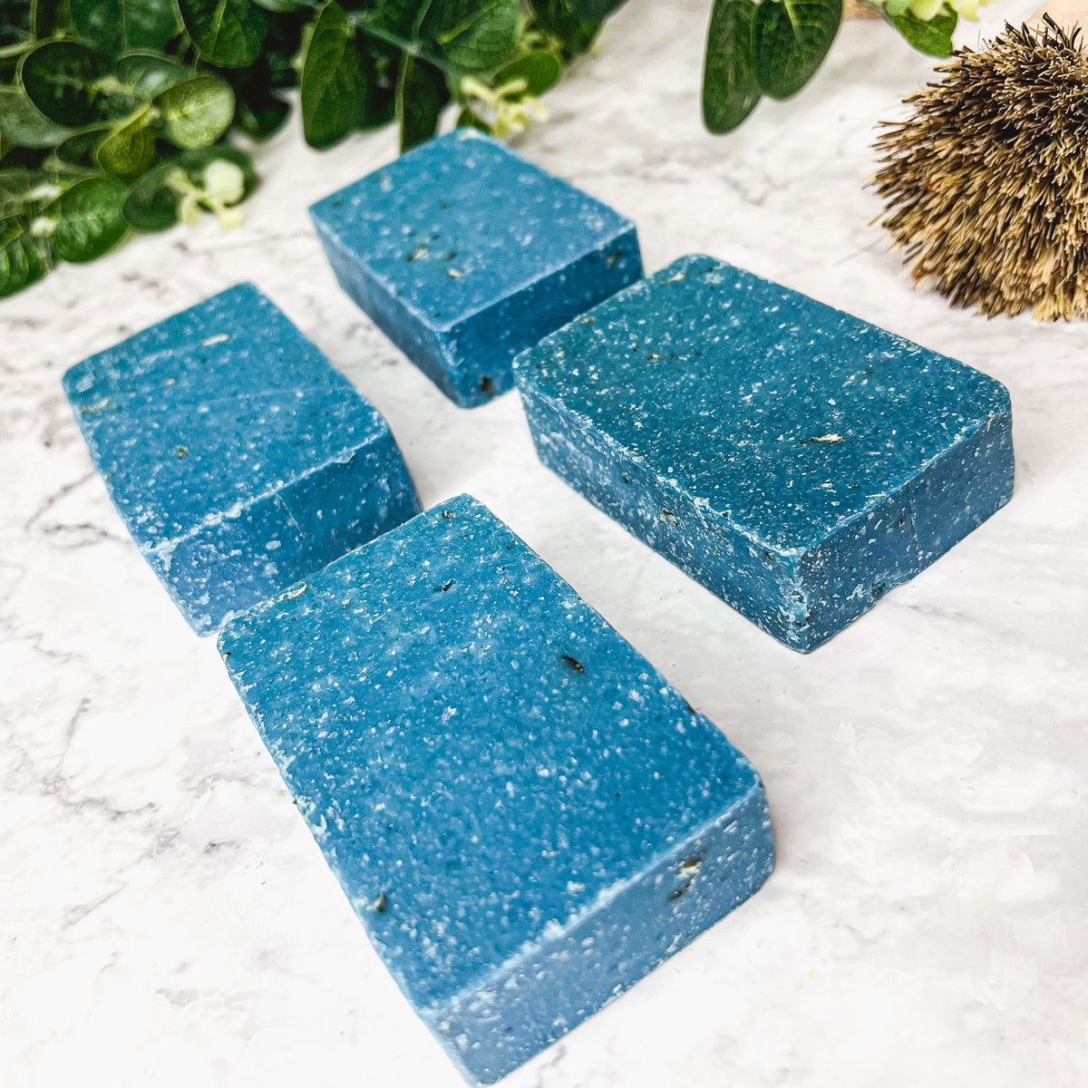 A vibrant blue bar of Blueberry Scrub soap with visible oatmeal and sea salt, showcasing its handcrafted design and rich color.