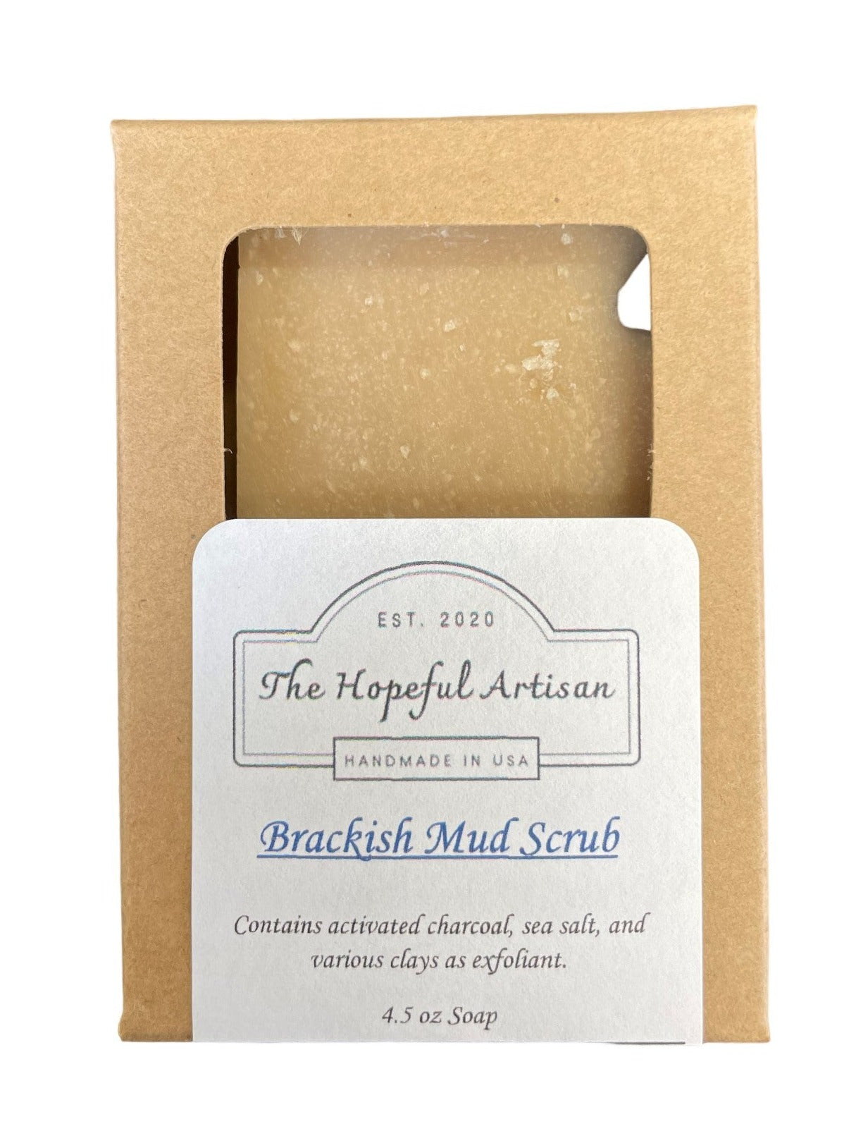 Brackish Mud Scrub in a jar with natural ingredients like charcoal and clays, showcasing its earthy texture and rich color.