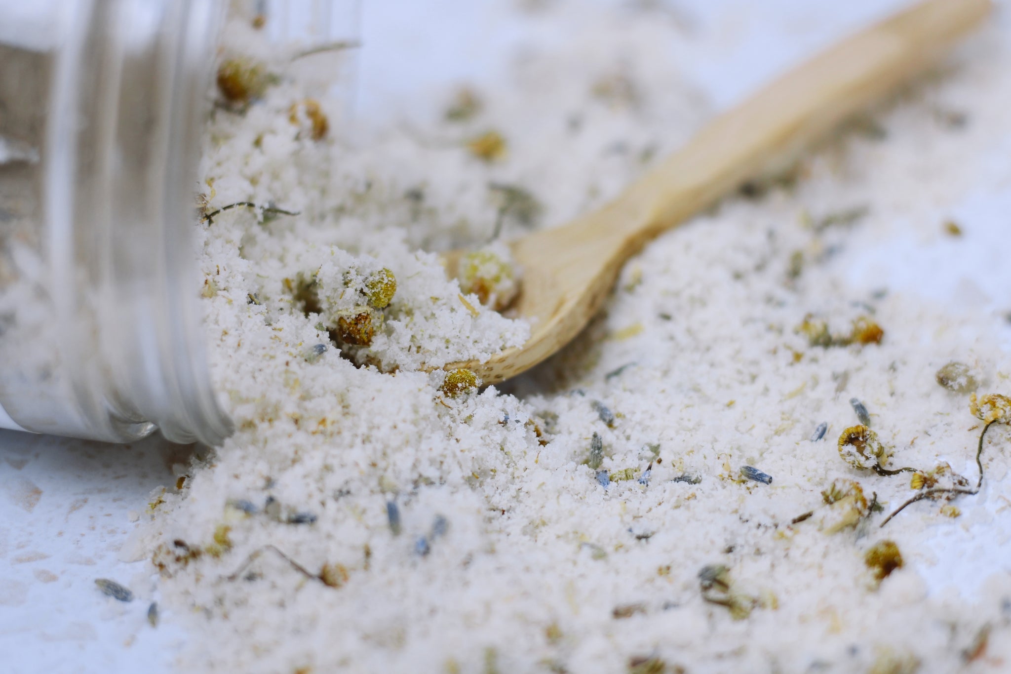 A jar of Chamomile Lavender + Coconut Milk Bath Soak with dried lavender buds and coconut milk powder, showcasing its natural ingredients.