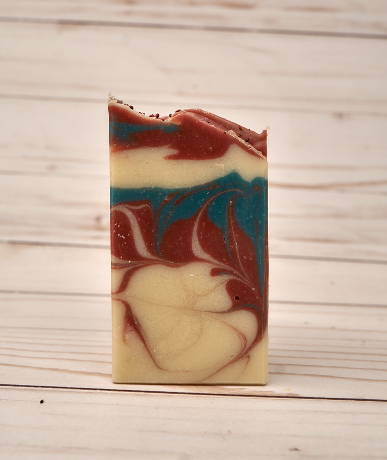 A beautifully crafted bar of Cranberry Fig Soap with vibrant colors and a festive design, showcasing its natural ingredients and eco-friendly glitter.