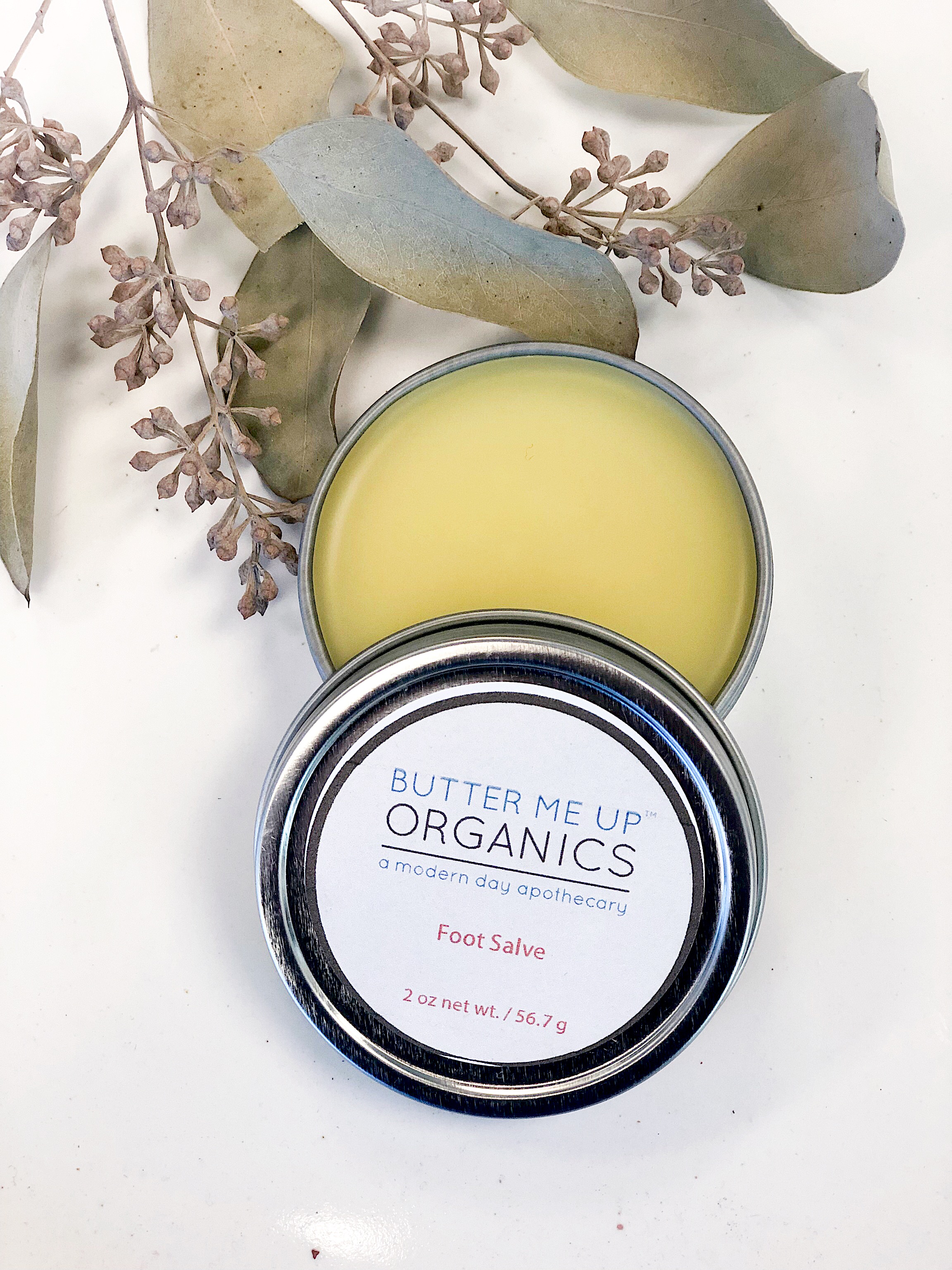 A 2oz tin of Foot Salve featuring a blend of natural butters and oils, designed to hydrate and repair cracked heels and rough feet.