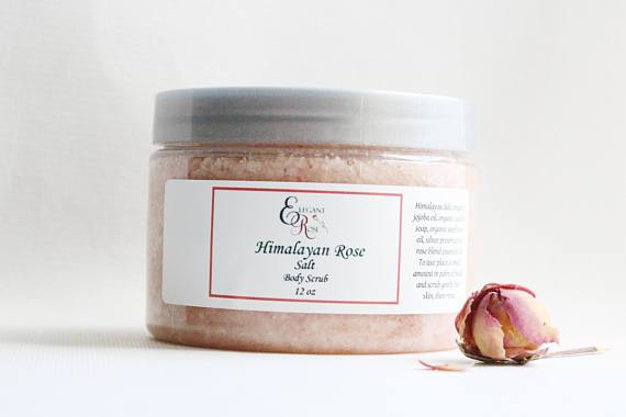 A jar of Himalayan Rose Salt Body Scrub with a pink hue, surrounded by Himalayan salt crystals and fresh grapefruit slices, showcasing its natural ingredients.