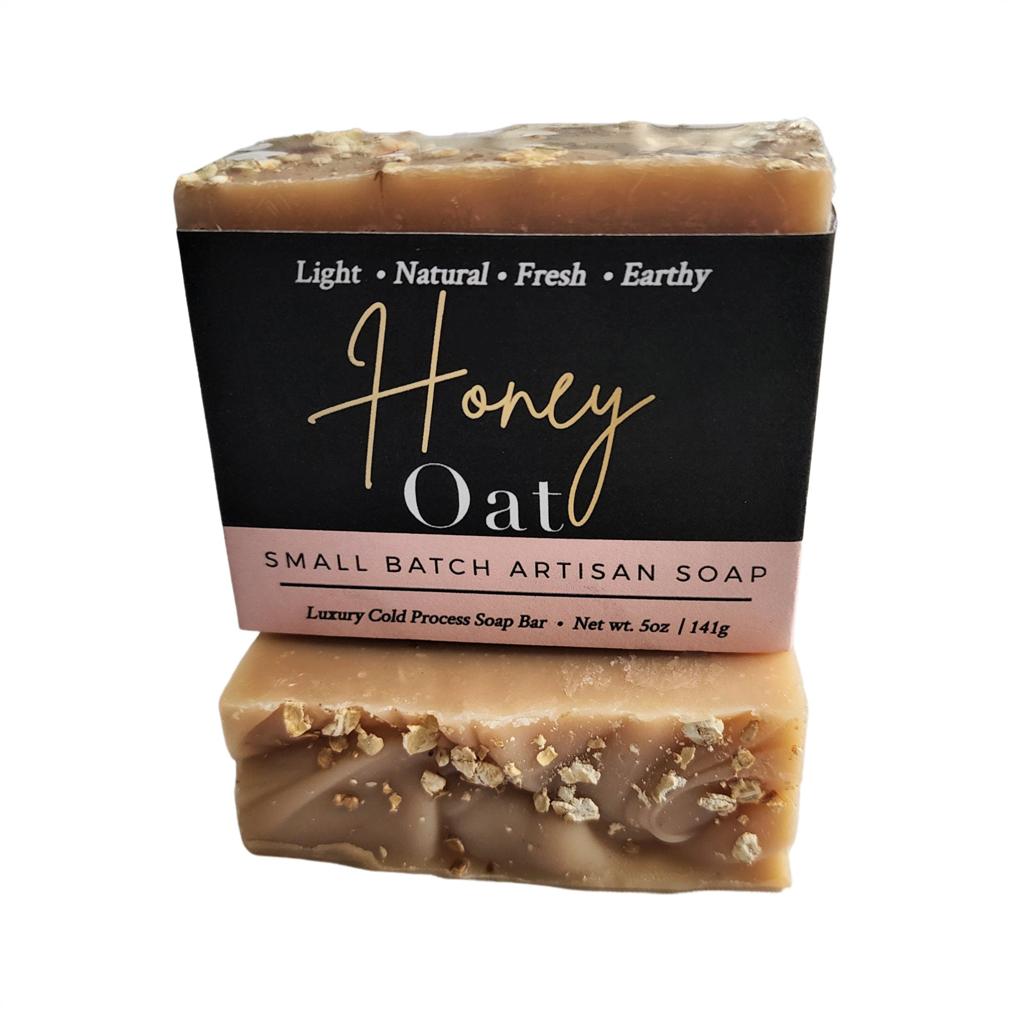 A rustic Honey Oat Soap bar featuring a light honey color and visible oat flakes, wrapped in eco-friendly packaging.