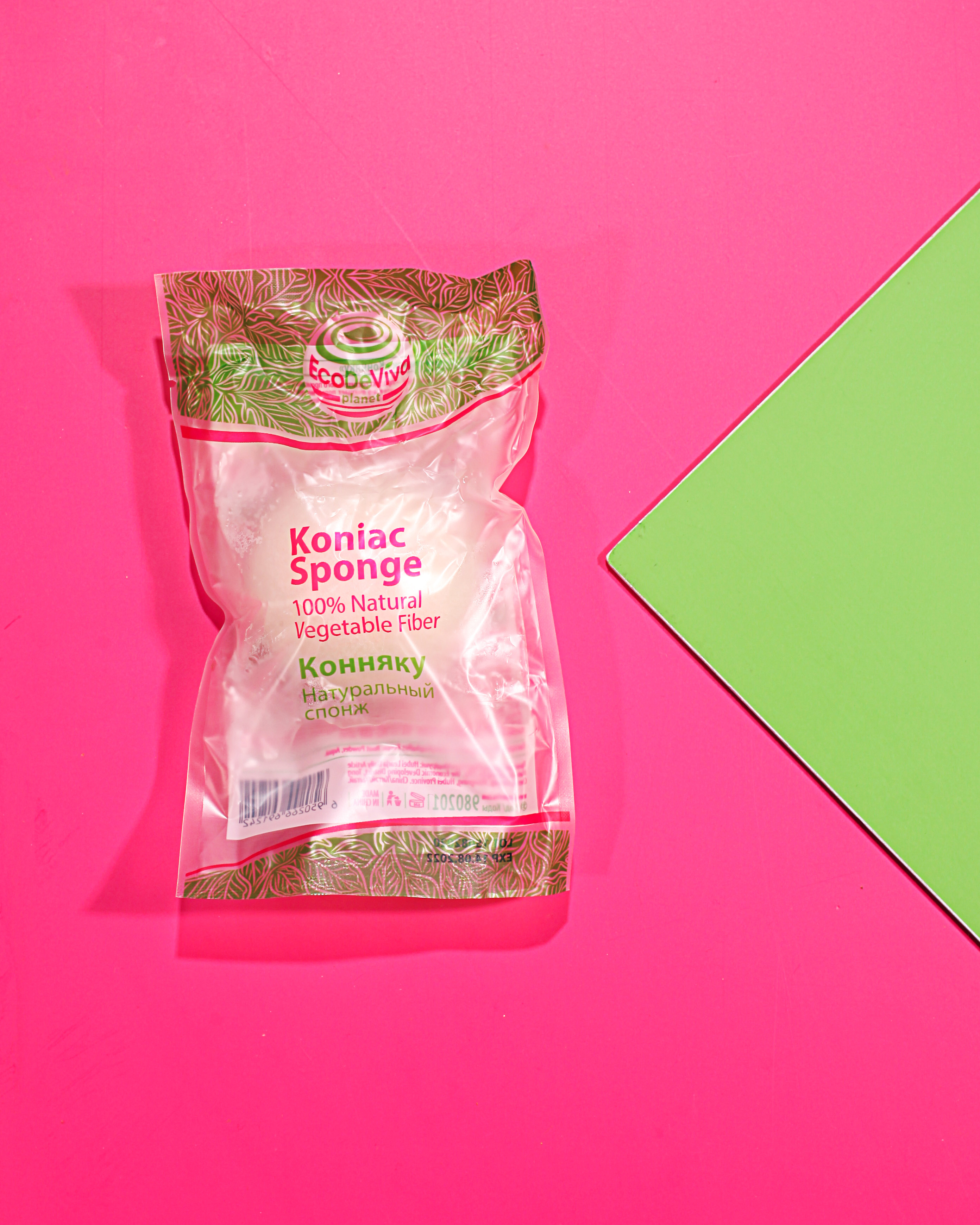 Packaged konjac sponge on pink background.