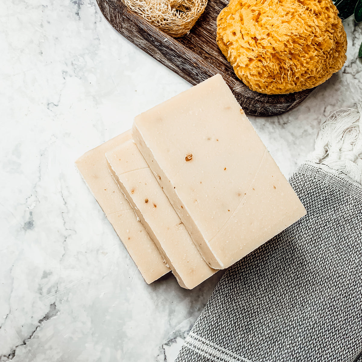 Lavender + Patchouli soap bar with real lavender buds, showcasing its handcrafted design and natural colors.