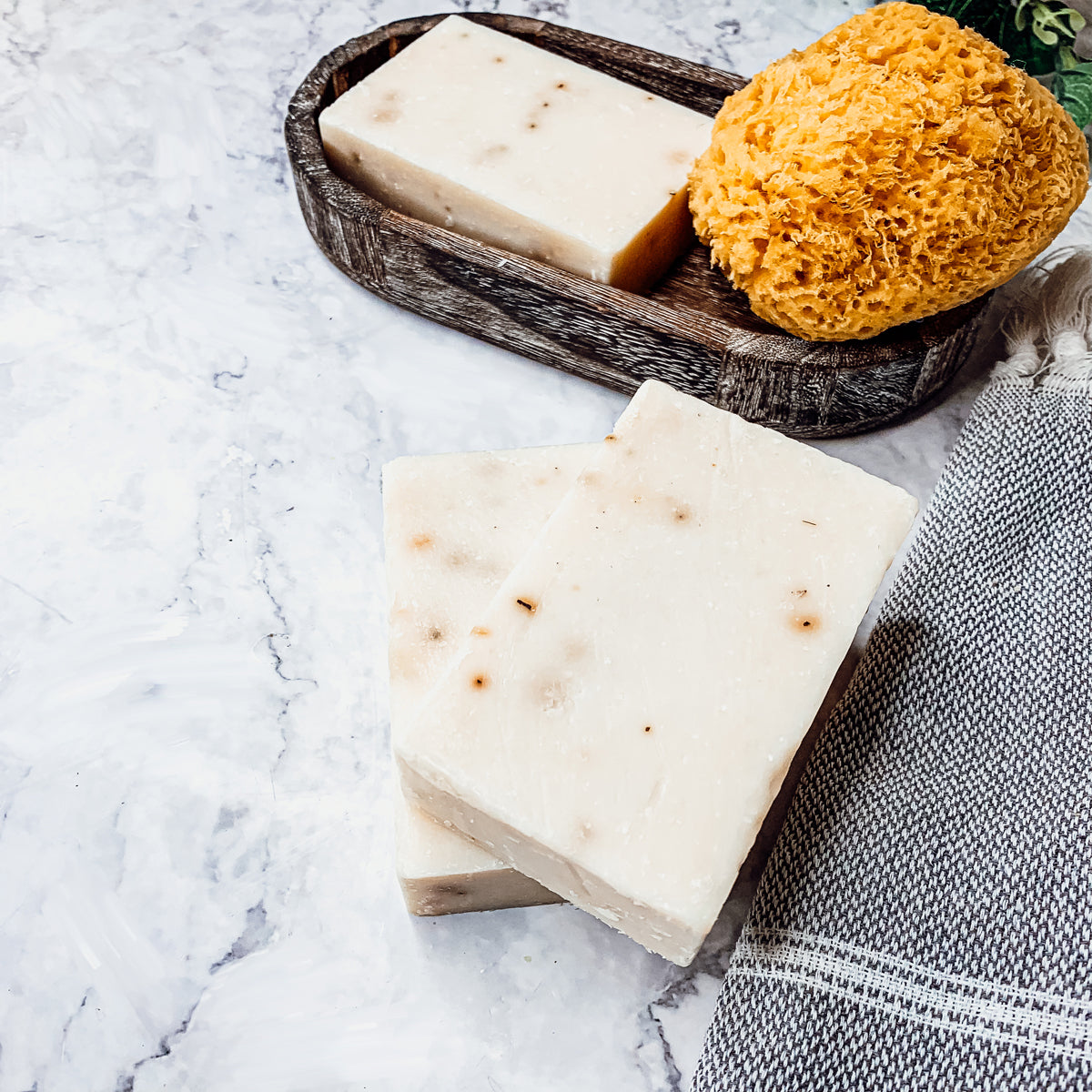 Lavender + Patchouli soap bar with real lavender buds, showcasing its handcrafted design and natural colors.