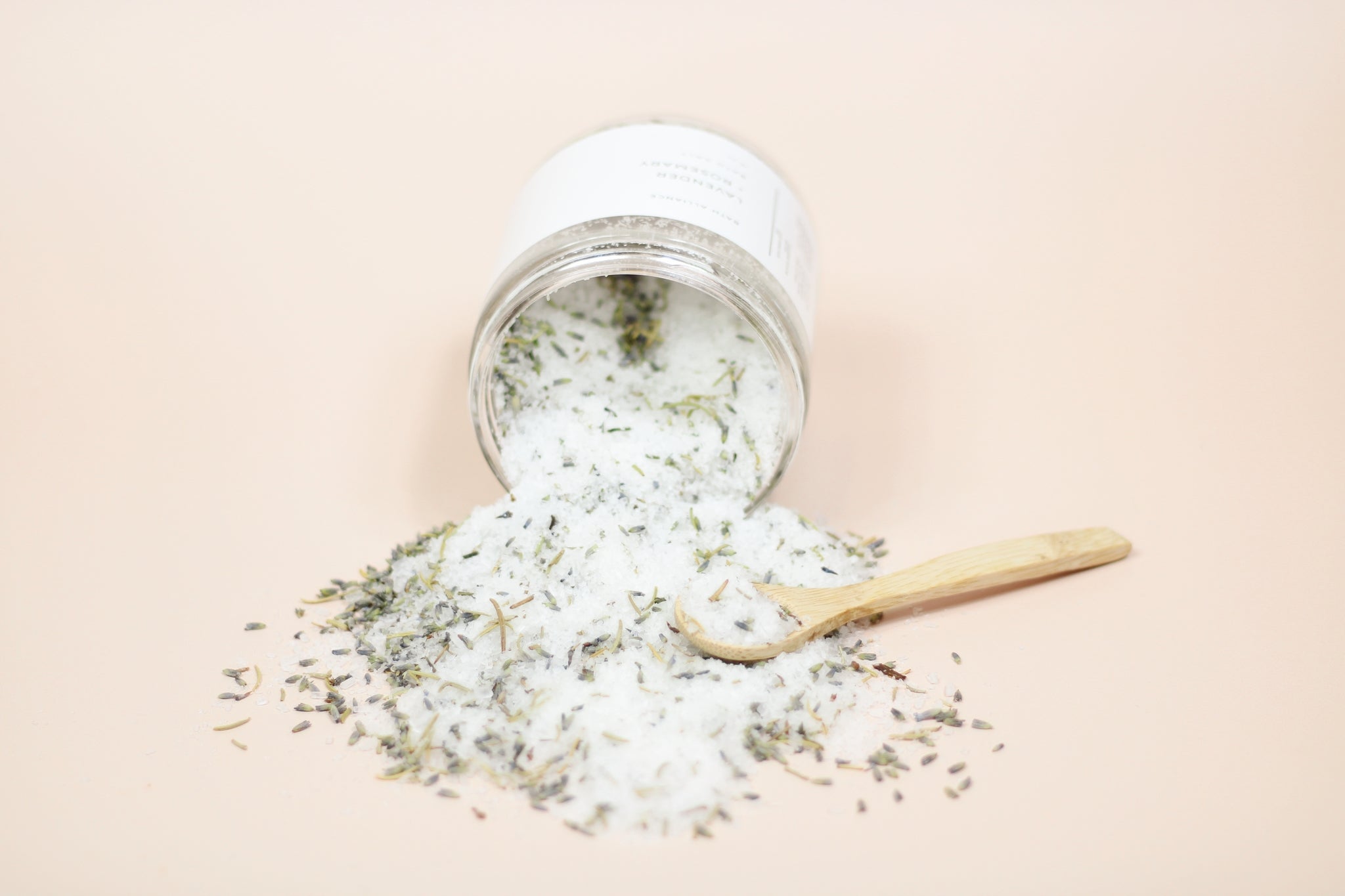 A resealable kraft pouch filled with Lavender + Rosemary Bath Salt, showcasing dried lavender buds and rosemary leaves.