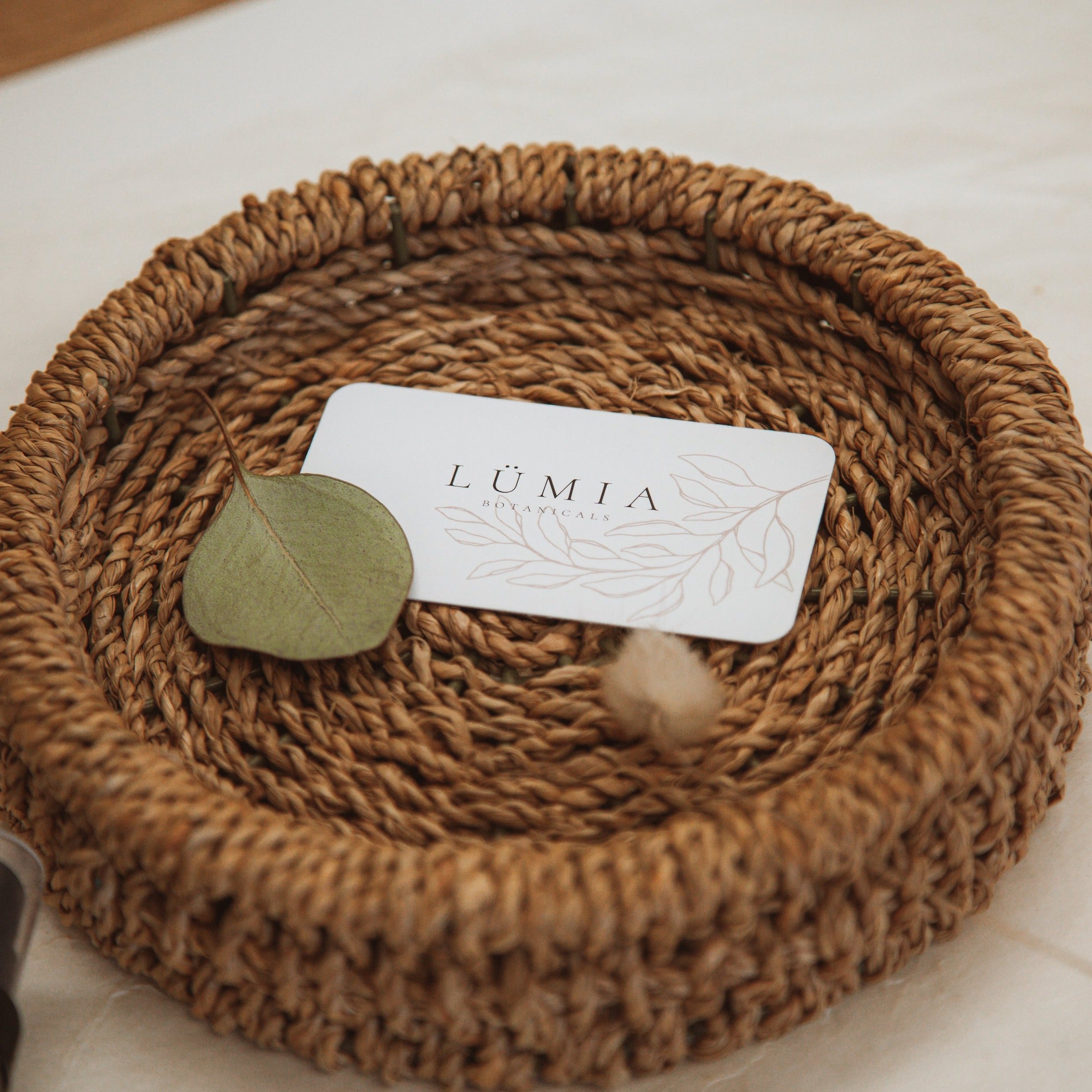 Lümia Botanicals E-Gift Card displayed on a wooden table with natural elements.