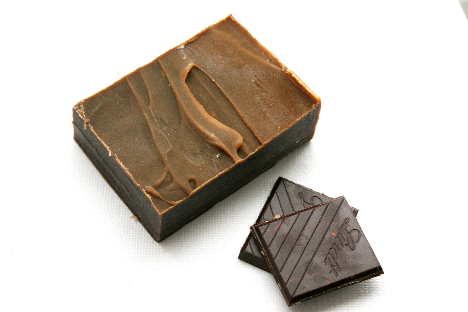 A luxurious chocolate soap bar made with organic cocoa butter and coconut milk, featuring a rich brown color and creamy texture, perfect for a pampering shower experience.