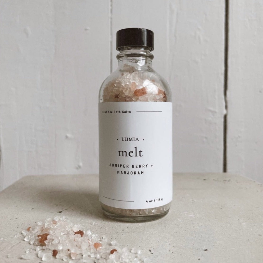 Melt Bath Salts in a clear jar, showcasing the pink and white salt crystals with essential oil ingredients in the background.