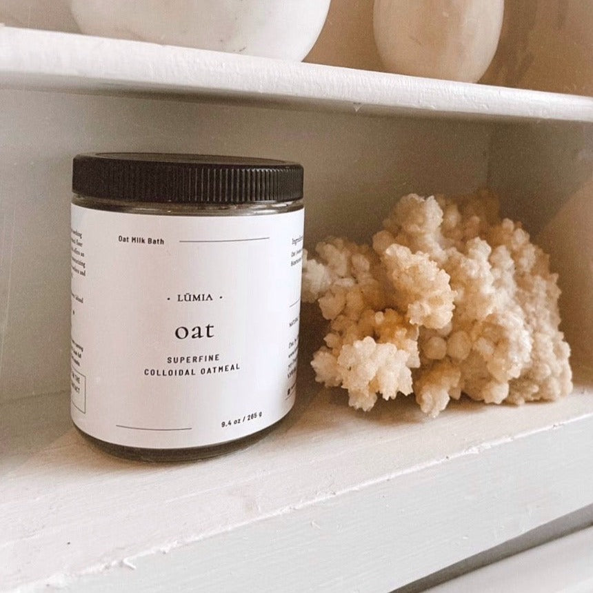 A soothing Oat Milk Bath Soak in a clear container, showcasing its fine texture and natural ingredients, perfect for skin relief.