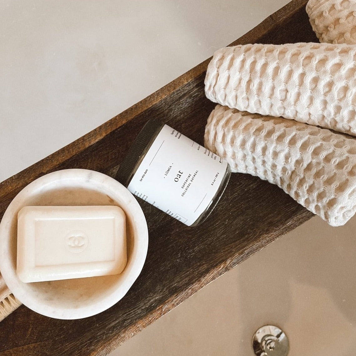 A soothing Oat Milk Bath Soak in a clear container, showcasing its fine texture and natural ingredients, perfect for skin relief.