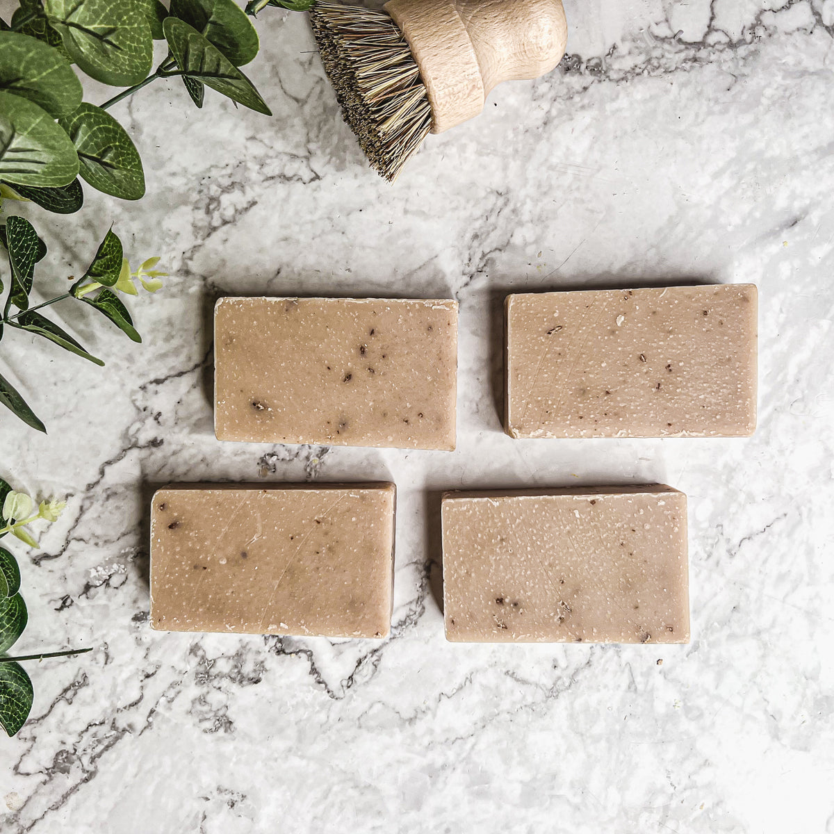 A bar of Oatmeal Milk & Honey soap with a creamy texture, featuring visible ground oatmeal particles and a light, natural color.