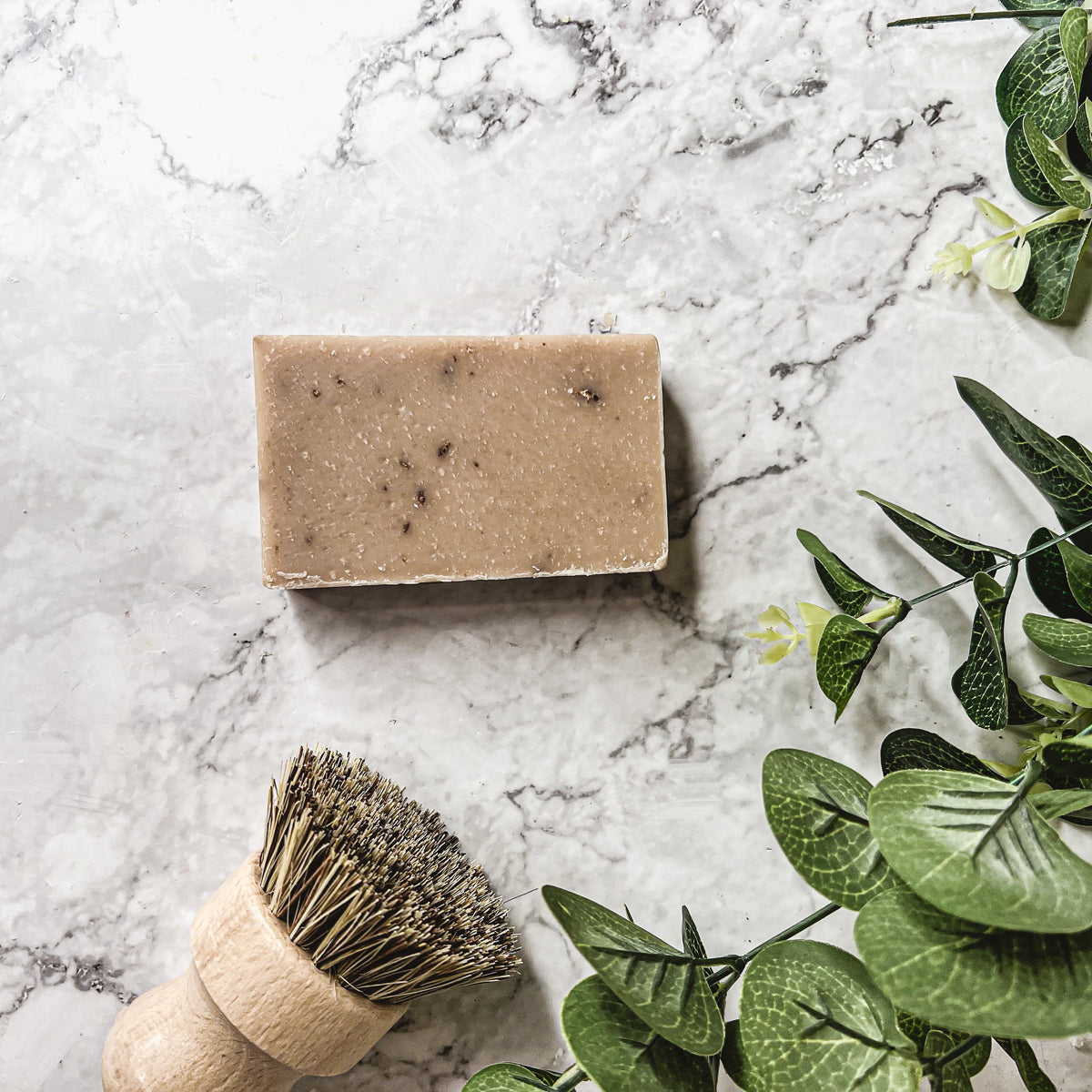 A bar of Oatmeal Milk & Honey soap with a creamy texture, featuring visible ground oatmeal particles and a light, natural color.