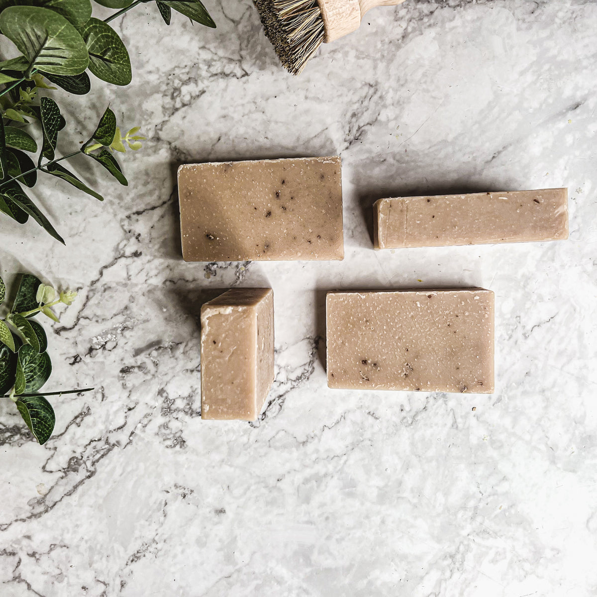 A bar of Oatmeal Milk & Honey soap with a creamy texture, featuring visible ground oatmeal particles and a light, natural color.