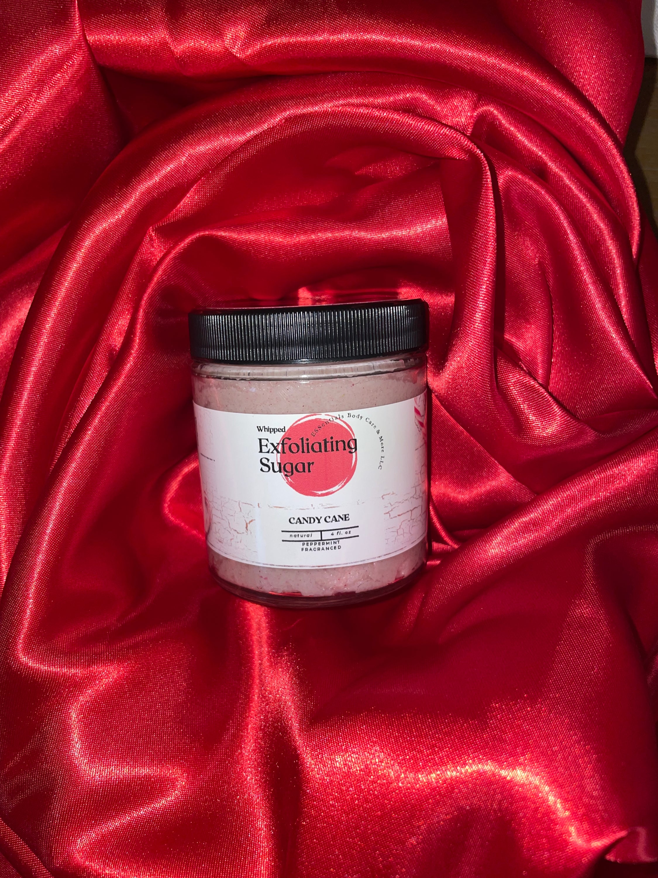 A jar of Peppermint exfoliating sugar scrub with a refreshing minty scent, showcasing its creamy texture and organic ingredients.