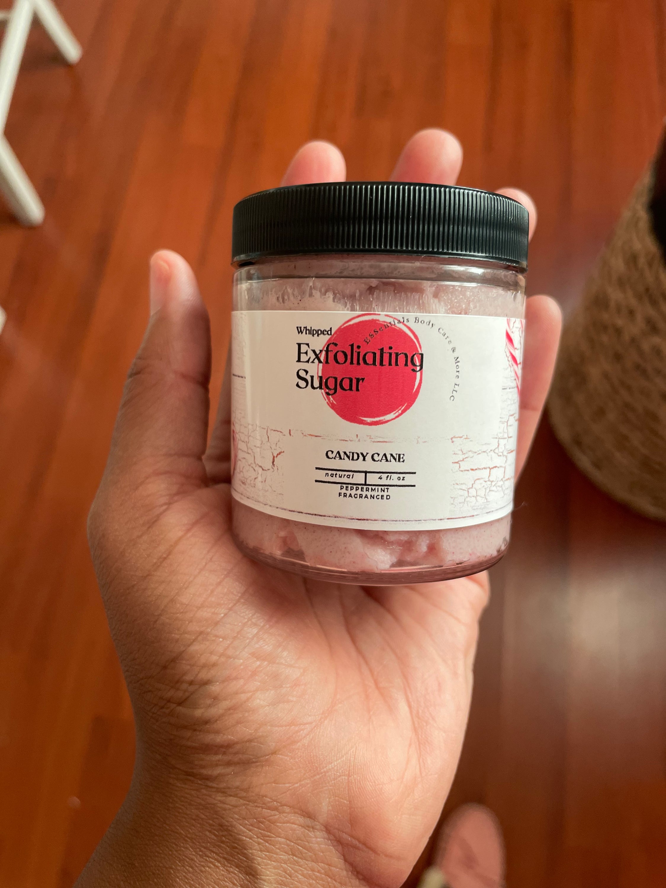 A jar of Peppermint exfoliating sugar scrub with a refreshing minty scent, showcasing its creamy texture and organic ingredients.