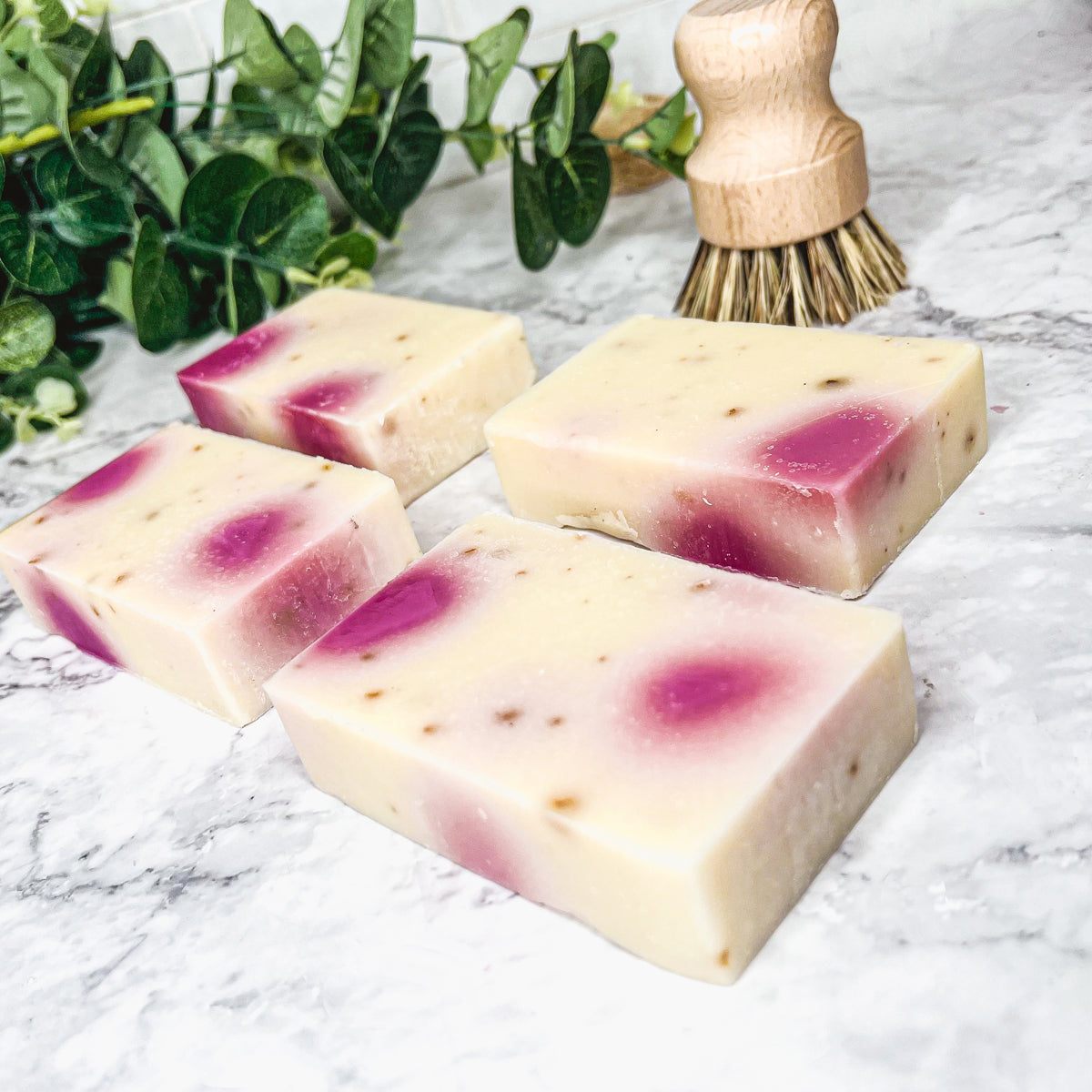 A beautifully handcrafted soap bar named Petal Dance, featuring real rose petals and a vibrant design, showcasing its organic ingredients.