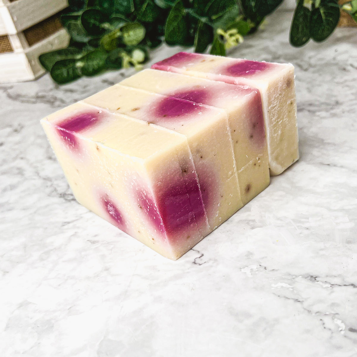 A beautifully handcrafted soap bar named Petal Dance, featuring real rose petals and a vibrant design, showcasing its organic ingredients.