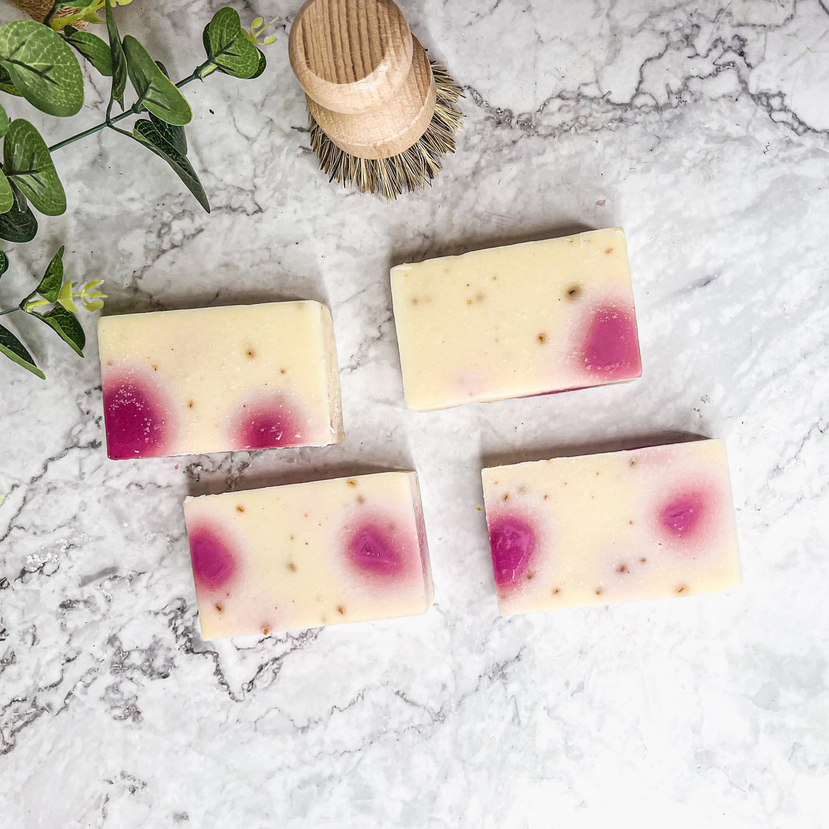 A beautifully handcrafted soap bar named Petal Dance, featuring real rose petals and a vibrant design, showcasing its organic ingredients.