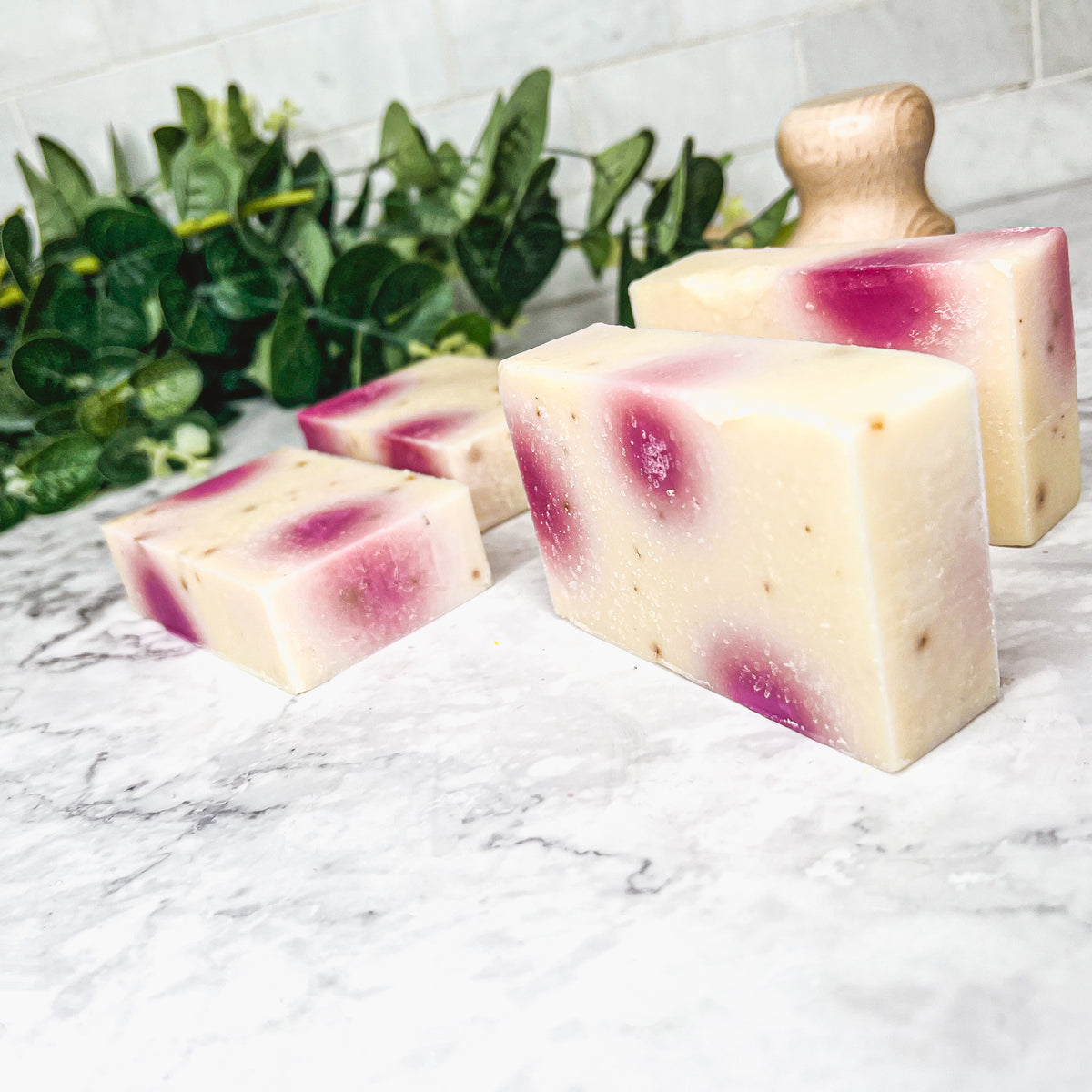 A beautifully handcrafted soap bar named Petal Dance, featuring real rose petals and a vibrant design, showcasing its organic ingredients.