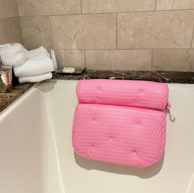 A luxurious pink bathtub pillow with ergonomic design, featuring soft mesh fabric and non-slip suction cups for ultimate comfort.