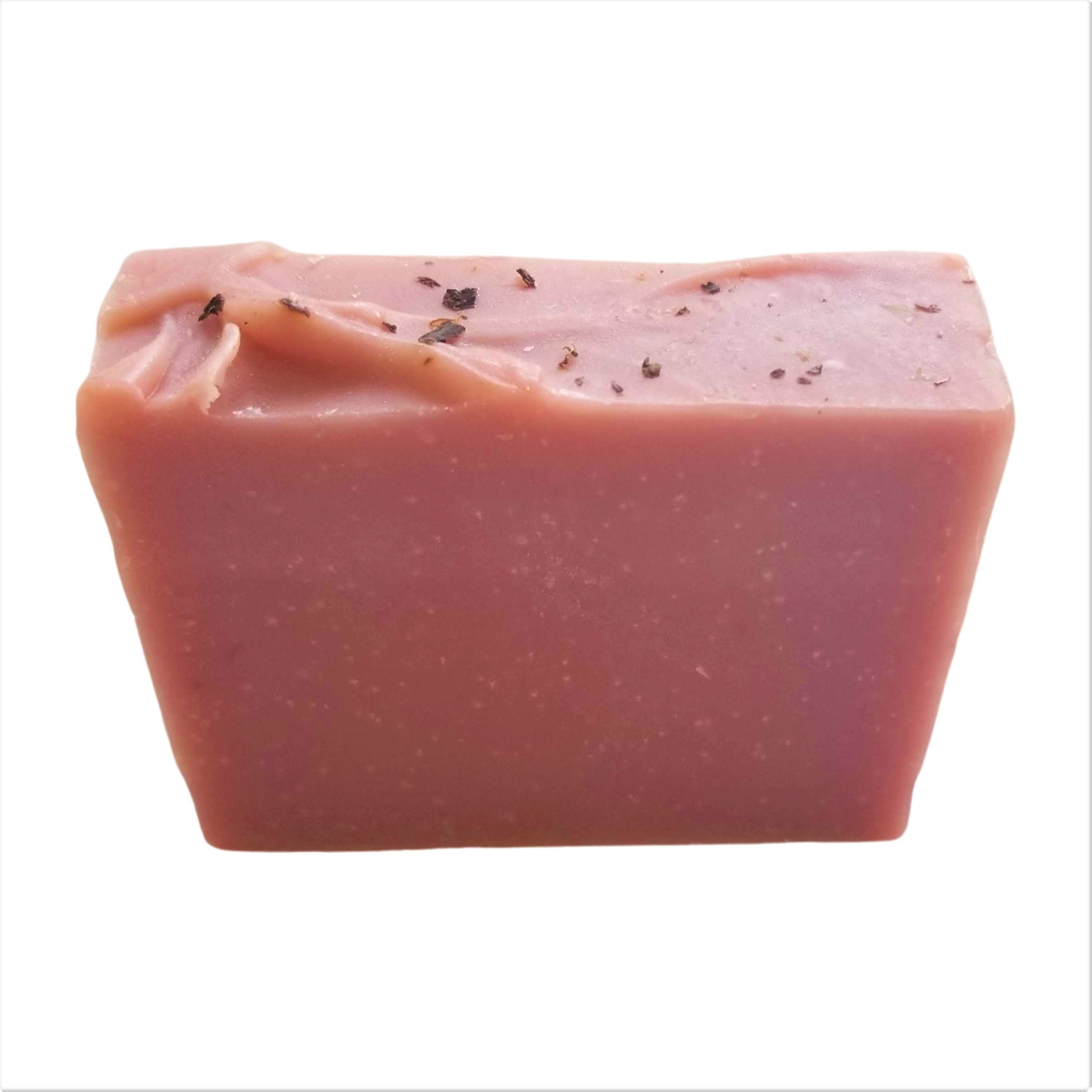 A beautifully crafted Rose Geranium Soap bar with pink clay and crushed rose petals, showcasing its delicate texture and vibrant color.