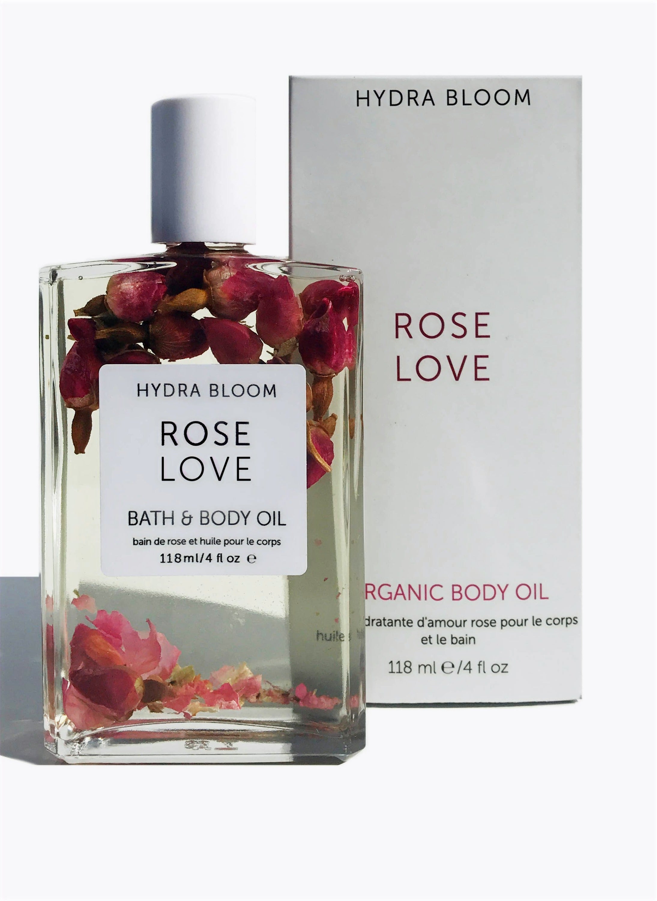 A bottle of Hydra Bloom Rose Love Bath & Body Oil with organic rose buds and essential oils, elegantly designed for skincare.