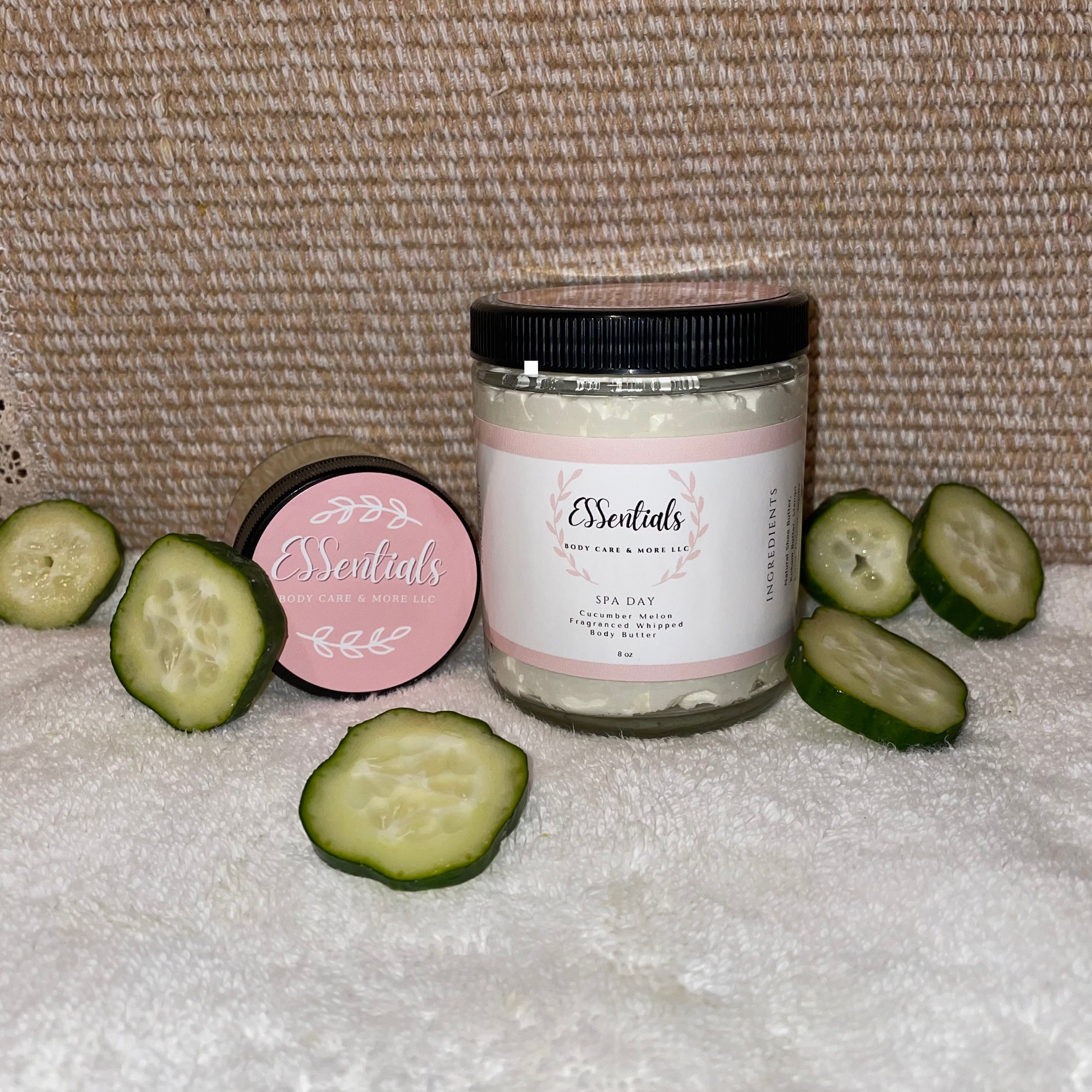 A luxurious jar of Spa Day body butter with cucumber melon fragrance, surrounded by natural ingredients like shea butter and coconut oil.